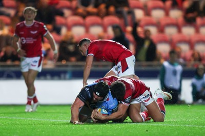 260926 - Scarlets v Cardiff Rugby - United Rugby Championship - Efan Lloyd of Cardiff goes over for a try despite the tackle of Eddie James of Scarlets