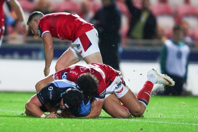 260926 - Scarlets v Cardiff Rugby - United Rugby Championship - Efan Lloyd of Cardiff goes over for a try despite the tackle of Eddie James of Scarlets