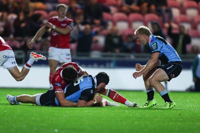 260926 - Scarlets v Cardiff Rugby - United Rugby Championship - Efan Lloyd of Cardiff goes over for a try despite the tackle of Eddie James of Scarlets