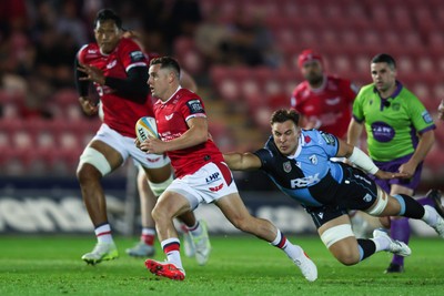 260926 - Scarlets v Cardiff Rugby - United Rugby Championship - Dane Blacker of Scarlets escapes the tackle of Taine Basham of Cardiff