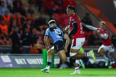 260926 - Scarlets v Cardiff Rugby - United Rugby Championship - Sam Lousi of Scarlets takes on Cameron Winnett of Cardiff