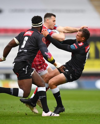 250323 - Scarlets v Sharks - United Rugby Championship - Gareth Davies of Scarlets takes on Siya Kolisi and Curwin Bosch of Sharks