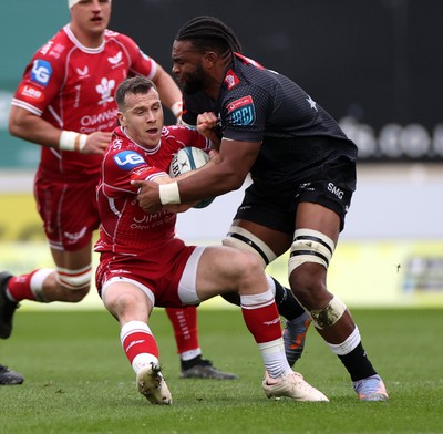 250323 - Scarlets v Cell C Sharks - United Rugby Championship - Gareth Davies of Scarlets is tackled by Vincent Tshituka of Sharks 