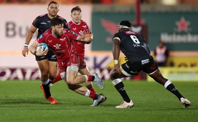 250323 - Scarlets v Cell C Sharks - United Rugby Championship - Johnny Williams of Scarlets is challenged by Siya Kolisi of Sharks 