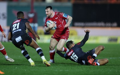 250323 - Scarlets v Cell C Sharks - United Rugby Championship - Ryan Conbeer of Scarlets is challenged by Boeta Chamberlain of Sharks 