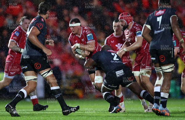 250323 - Scarlets v Cell C Sharks - United Rugby Championship - Aaron Shingler of Scarlets is tackled by Bongi Mbonambi of Sharks 