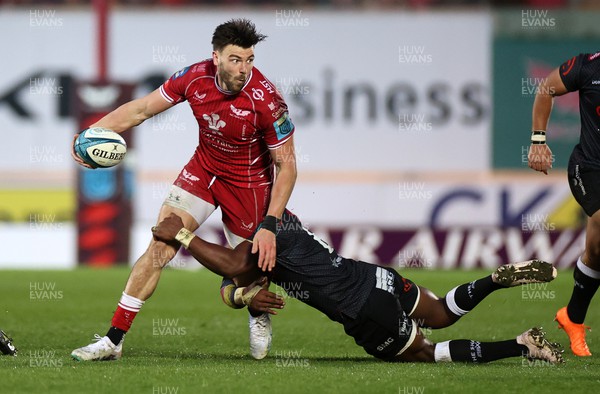 250323 - Scarlets v Cell C Sharks - United Rugby Championship - Johnny Williams of Scarlets is tackled by Siya Kolisi of Sharks 