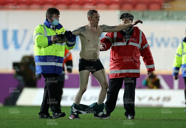 190222 - Scarlets v Connacht - United Rugby Championship - A pitch invader is escorted off the field