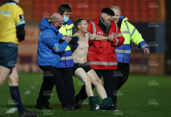 190222 - Scarlets v Connacht - United Rugby Championship - A pitch invader is escorted off the field