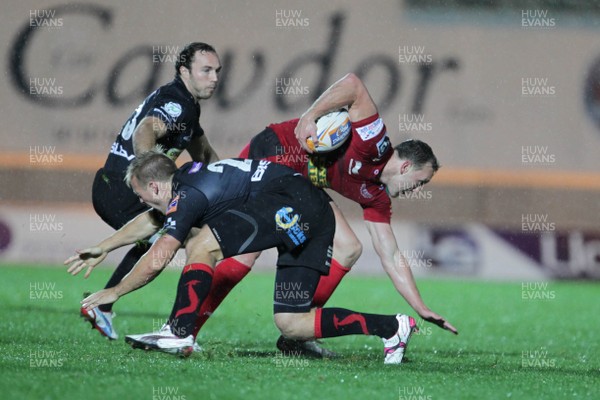 051012 Scarlets v Dragons- RaboDirect Pro12 - Scarlets' Morgan Stoddart avoids tackles from Dragons' Ashley Smith and Will Harries 