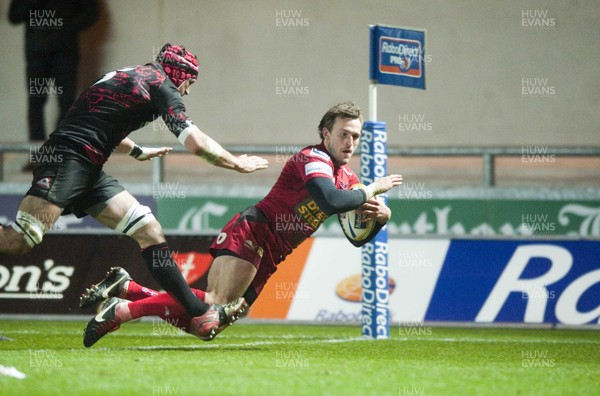 010313 - Scarlets v Edinburgh - RaboDirect PRO12 -Andy Fenby of Scarlets dives over to score as Edinburgh's Sean Cox closes in  