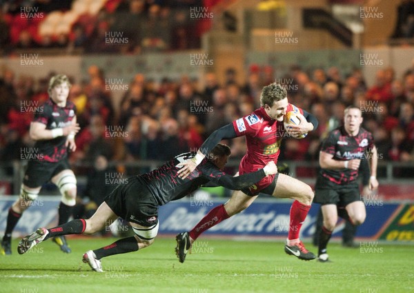 010313 - Scarlets v Edinburgh - RaboDirect PRO12 -Andy Fenby of Scarlets escapes the tackle of Edinbugh's Dougie Fife 