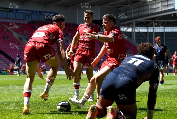 130621 - Scarlets v Edinburgh - Guinness PRO14 Rainbow Cup - Tom Rogers of Scarlets celebrates scoring try with Kieran Hardy and Steff Evans