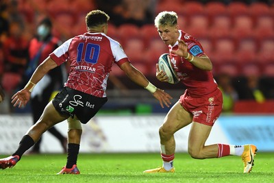 011021 - Scarlets v Emirates Lions - United Rugby Championship - Tom Rogers of Scarlets gets past Jordan Hendrikse of Lions