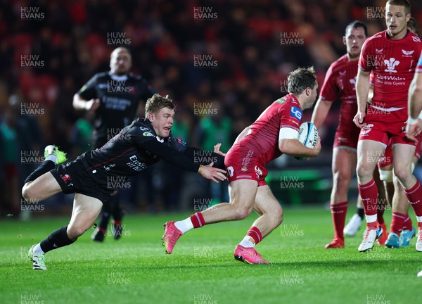 111123 - Scarlets v Emirates Lions, United Rugby Championship - Ioan Lloyd of Scarlets gets away from the challenge of Morne van den Berg of Lions