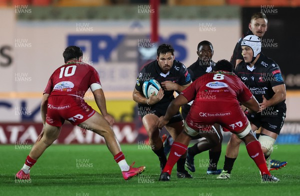 111123 - Scarlets v Emirates Lions, United Rugby Championship - Marius Louw of Lions takes on Eddie James of Scarlets and Carwyn Tuipulotu of Scarlets