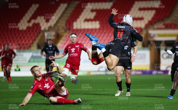 111123 - Scarlets v Emirates Lions, United Rugby Championship -Edwill van der Merwe of Lions is sent flying as Johnny McNicholl of Scarlets tackles