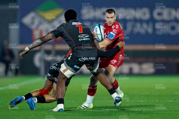 111123 - Scarlets v Emirates Lions - United Rugby Championship - Gareth Davies of Scarlets is tackled by Edwill van der Merwe and Emmanuel Tshituka of Lions