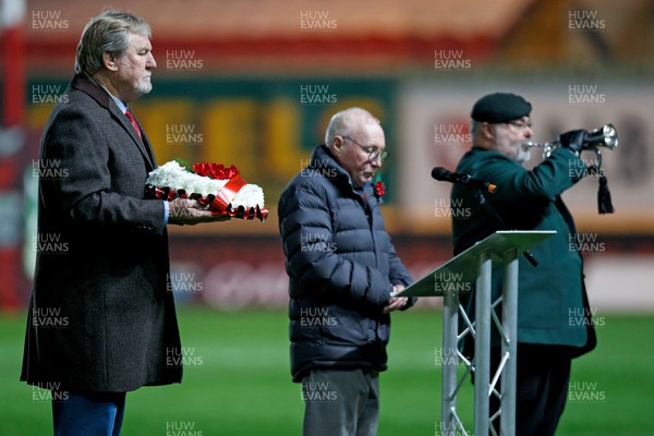 111123 - Scarlets v Emirates Lions - United Rugby Championship - Scarlets President Derek Quinnell with a wreath to mark Remembrance Day as a bugler plays the last post