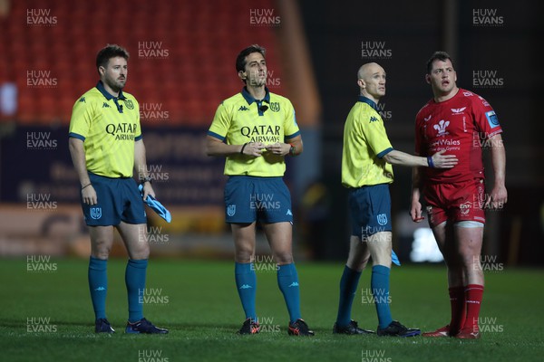 300324 - Scarlets v Glasgow Warriors - United Rugby Championship - Referee Gianluca Gnecci discusses Tom Rogers of Scarlets challenge with linesmen Ben Whitehouse John Darcy and Ryan Elias 