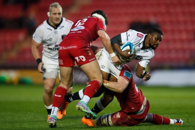 260424 - Scarlets v Hollywoodbets Sharks - United Rugby Championship - Siya Masuku of Sharks is tackled by Morgan Jones of Scarlets