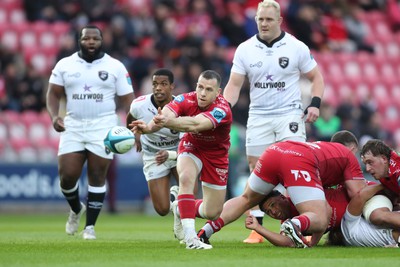 260424 - Scarlets v Hollywoodbets Sharks - United Rugby Championship - Gareth Davies of Scarlets gets the ball away 