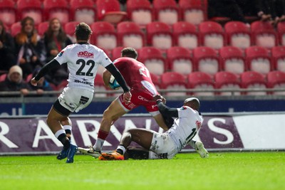 260424 - Scarlets v Hollywoodbets Sharks - United Rugby Championship - Kieran Hardy of Scarlets is stopped short of the line by Makazole Mapimpi of Sharks 