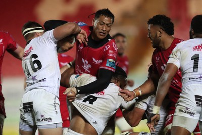 260424 - Scarlets v Hollywoodbets Sharks - United Rugby Championship - Sam Lousi of Scarlets is tackled by Kerron Van Vuurenand Vincent Tshhituka of Sharks 