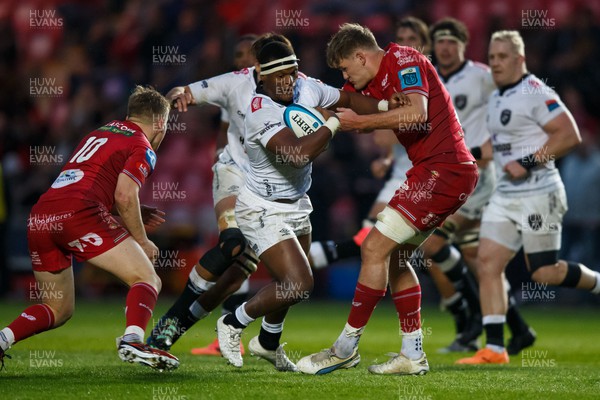 260424 - Scarlets v Hollywoodbets Sharks - United Rugby Championship - Phepsi Buthelezi of Sharks is tackled by Taine Plumtree of Scarlets