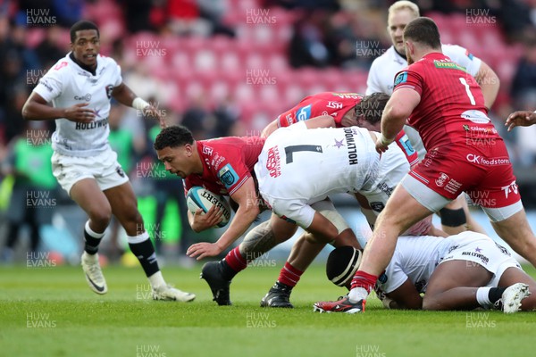 260424 - Scarlets v Hollywoodbets Sharks - United Rugby Championship - Dan Davis of Scarlets is tackled by Lappies Labuschagne of Sharks