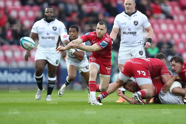 260424 - Scarlets v Hollywoodbets Sharks - United Rugby Championship - Gareth Davies of Scarlets gets the ball away 
