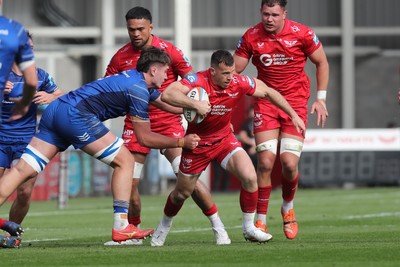 260425 - Scarlets v Leinster - United Rugby Championship - Gareth Davies of Scarlets breaks away from Leinsters Brian Deeny