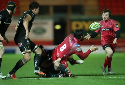 310115 - Scarlets v London Irish, LV= Cup - Scarlets Rory Pitman offloads to Rhodri Williams as he is tackled by London Irish's Darren Allinson