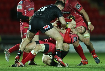 310115 - Scarlets v London Irish, LV= Cup - Scarlets Adam Warren looks for support as he's tackled and held by the London Irish defence