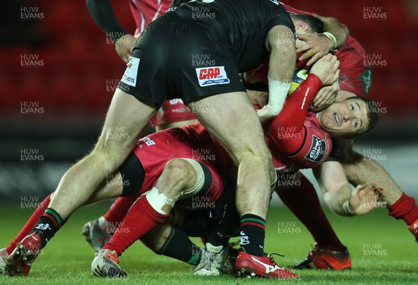 310115 - Scarlets v London Irish, LV= Cup - Scarlets Adam Warren looks for support as he's tackled and held by the London Irish defence