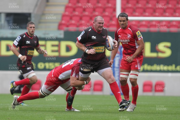 250812 - Scarlets v London Welsh - Preseason Friendly - Scarlets Phil John breaks an Ed Jackson tackle