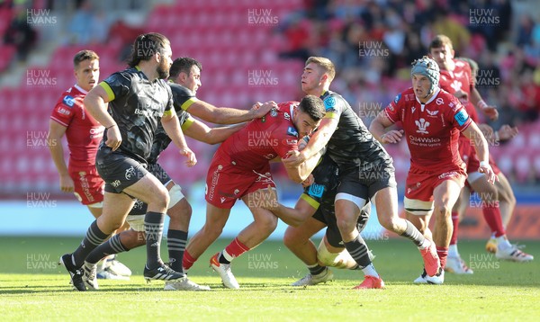 101021 - Scarlets v Munster - United Rugby Championship - Johnny Williams of Scarlets is tackled by the Munster defence