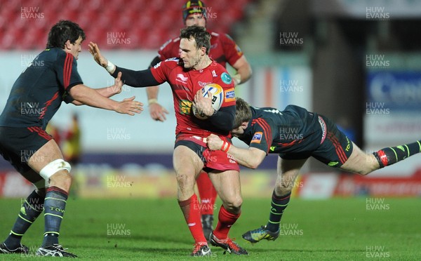 160213 - Scarlets v Munster - RaboDirect PRO12 -Andy Fenby of Scarlets takes on Donnacha O'Callaghan and Ivan Dineen of Munster