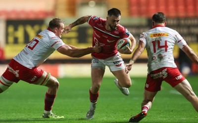 270925 - Scarlets v Munster, United Rugby Championship - Joe Roberts of Scarlets takes on Gavin Coombes of Munster