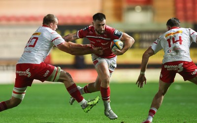 270925 - Scarlets v Munster, United Rugby Championship - Joe Roberts of Scarlets takes on Gavin Coombes of Munster