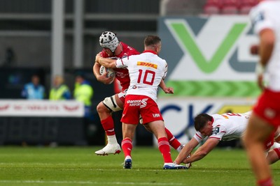 270925 - Scarlets v Munster - United Rugby Championship - Tristan Davies of Scarlets is tackled by JJ Hanrahan of Munster
