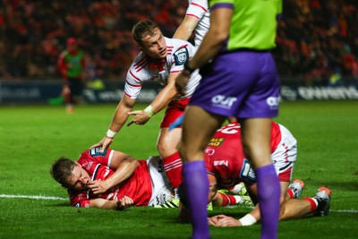 270925 - Scarlets v Munster - United Rugby Championship - Craig Casey of Munster calls for assistance for Sam Costelow of Scarlets after he was injured in a tackle