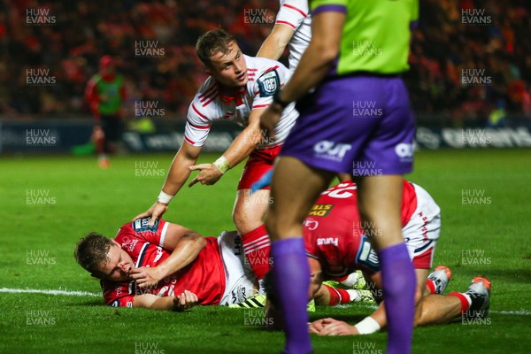 270925 - Scarlets v Munster - United Rugby Championship - Craig Casey of Munster calls for assistance for Sam Costelow of Scarlets after he was injured in a tackle