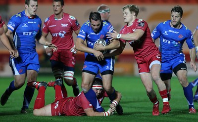 081016 - Scarlets v Newport Gwent Dragons - Guinness PRO12 - Charlie Davies of Newport Gwent Dragons is tackled by Wyn Jones and Aled Davies of Scarlets