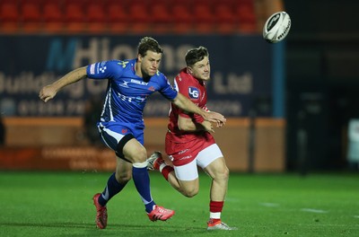 081016 - Scarlets v Newport Gwent Dragons, Guinness PRO12 - Steff Evans of Scarlets is challenged by Pat Howard of Newport Gwent Dragons as he kicks ahead