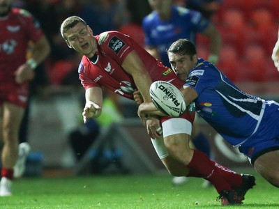 081016 - Scarlets v Newport Gwent Dragons, Guinness PRO12 - Scott Williams of Scarlets is tackled by Charlie Davies of Newport Gwent Dragons