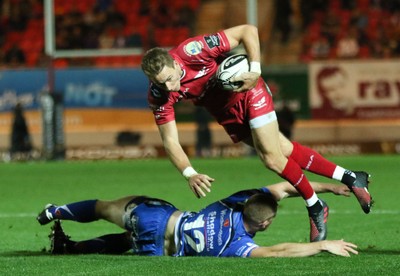 081016 - Scarlets v Newport Gwent Dragons, Guinness PRO12 - Liam Williams of Scarlets breaks through the tackle from Jack Dixon of Newport Gwent Dragons to score try