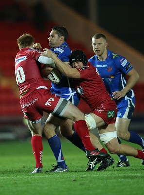 081016 - Scarlets v Newport Gwent Dragons, Guinness PRO12 - Charlie Davies of Newport Gwent Dragons is tackled by Rhys Patchell of Scarlets and James Davies of Scarlets