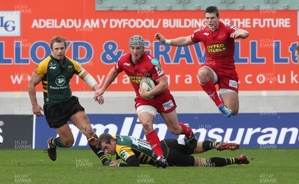 14.01.12 Scarlets v Northampton... Scarlets Jonathan Davies beats tackle by Stephen Myler as Scott Williams gets airborne.  