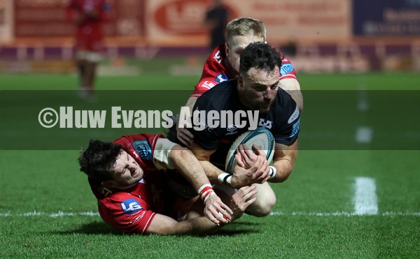 010122 - Scarlets v Ospreys - United Rugby Championship - Luke Morgan of Ospreys beats Dan Jones and Johnny McNicholl of Scarlets to the ball to score a try